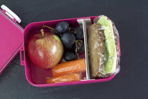 Zdravý oběd box, sýrový sendvič, jablko, mrkev a hrozny — Stock fotografie