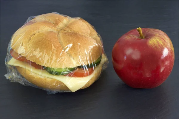 Sandwich mit Stretchfolie und rotem Apfel — Stockfoto