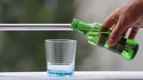 Agua mineral fría que vierte de la botella de vidrio en un vaso — Vídeos de Stock