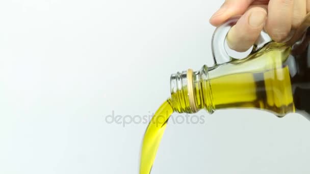 Versare l'olio extravergine di oliva dalla bottiglia di vetro . — Video Stock