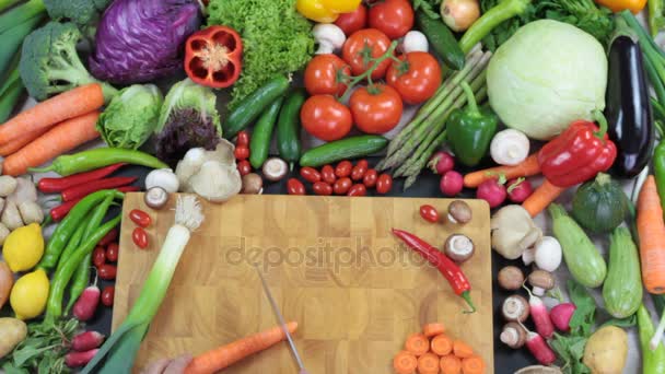 Verduras frescas y zanahoria picada en la tabla de picar — Vídeo de stock