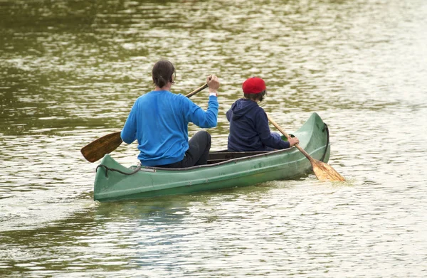 カヌーツアーの家族。父と子でカヤックを漕ぐ ストック画像