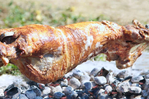 Turning roasted whole lamb on coal fire — Stock Photo, Image