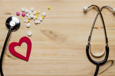 Kırmızı kalpli, steteskoplu ve haplı bir sağlık sigortası formu. Sağlık ve tıbbi konsept. Üst görünüm.