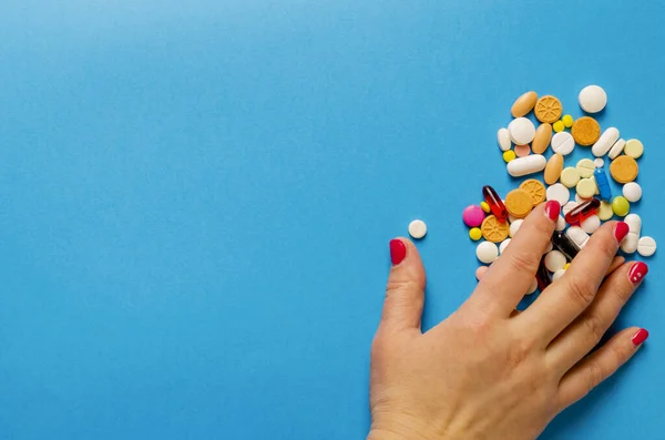 Mano Femminile Che Prende Pillole Multicolori Sdraiato Uno Sfondo Blu — Foto Stock