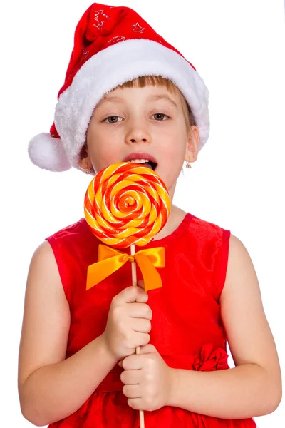 Retrato navideño de una niña, sombrero de Santa Claus con caramelo — Foto de Stock