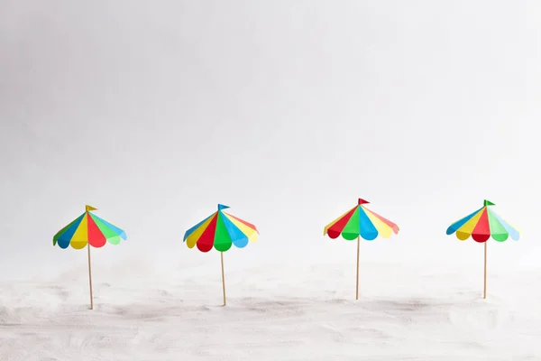 Fyra parasoll på sand papper — Stockfoto