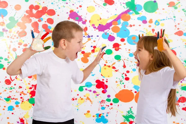 Kleiner Junge und Mädchen, um auf seine Hände zu malen, die einander anschreien — Stockfoto