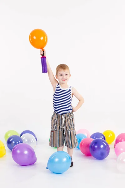 Băiatul umflă balonul pe fundalul alb — Fotografie, imagine de stoc
