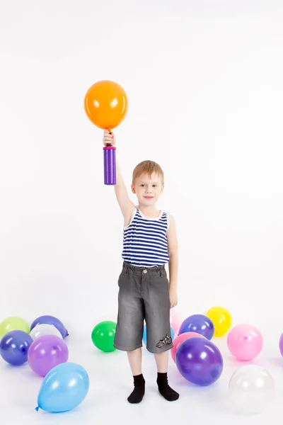 Het jongetje wordt opgeblazen ballon op de witte achtergrond van de — Stockfoto