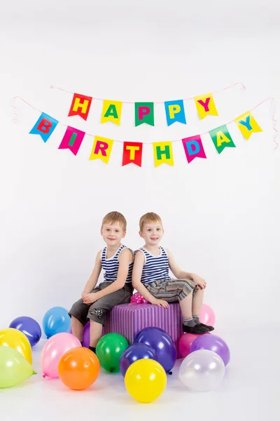 Doi băieți care stau cu un cadou pe un fundal alb, inscripția La mulți ani — Fotografie, imagine de stoc