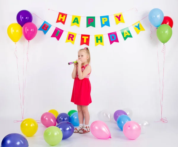 Дівчина тримає свисток стоїть поруч з повітряними кулями напис з днем народження, білий фон — стокове фото
