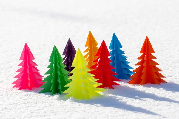 Kolorowe choinkowe z papieru w śniegu. — Zdjęcie stockowe