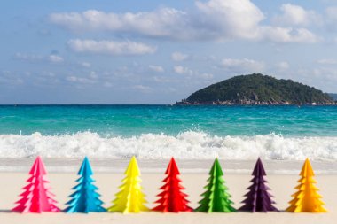 Yedi kağıt Noel ağaçları kum mavi denize karşı durmak. Similan Adaları