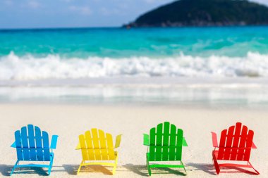 Plaj sandalyeleri oturup sahilde kırma yumuşak okyanus dalgalarının rahatlayın turistler için kumlu plajları üzerinde. Kağıttan yapılmış.