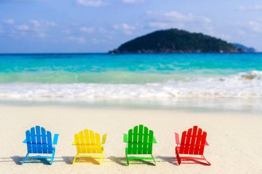 Plaj sandalyeleri oturup sahilde kırma yumuşak okyanus dalgalarının rahatlayın turistler için kumlu plajları üzerinde. Kağıttan yapılmış.