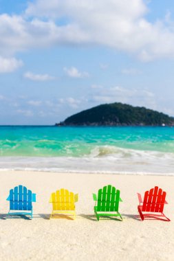 Plaj sandalyeleri oturup sahilde kırma yumuşak okyanus dalgalarının rahatlayın turistler için kumlu plajları üzerinde. Kağıttan yapılmış.