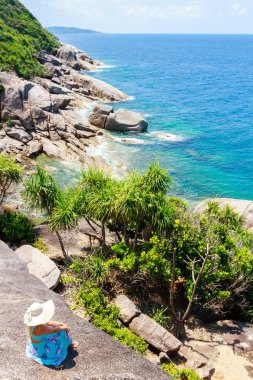 Mavi elbiseli kız taş üzerine oturan ve ufuk mesafe içine arıyorum