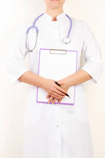 Médico segurando um computador tablet enquanto o usa isolado em fundo branco — Fotografia de Stock