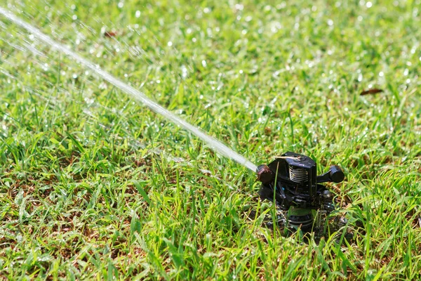 Автоматичний спринклер садового газону в дії поливу трави . — стокове фото