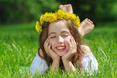 dandelions ile yeşil çayır üzerinde oturan tatlı güzel kız