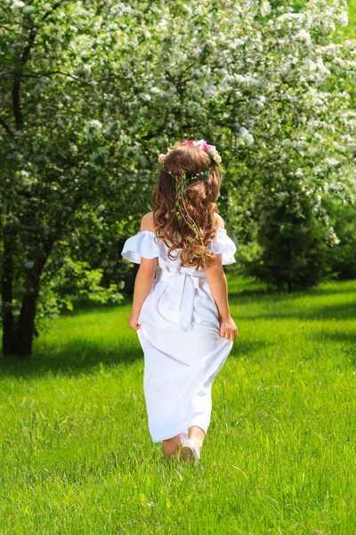 Dziewczyna w białej sukni na tle zielonego parku. PID z tyłu. — Zdjęcie stockowe