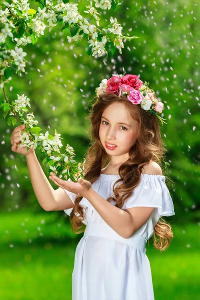 Bájos lány egy virágzó Alma gyümölcsös, egy napsütéses tavaszi napon — Stock Fotó