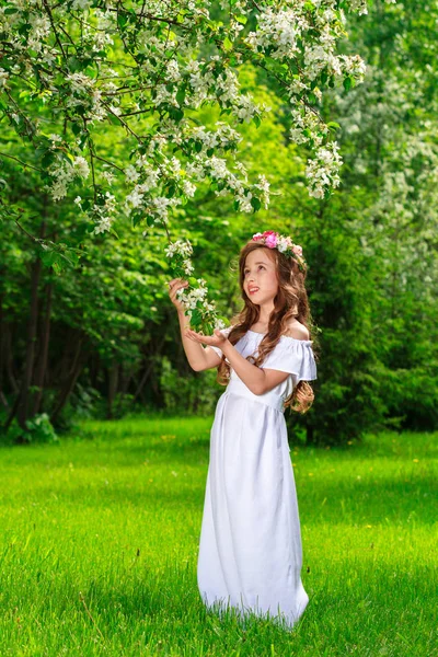 Charmante meisje in een bloeiende boomgaard van Apple op een zonnige lentedag — Stockfoto
