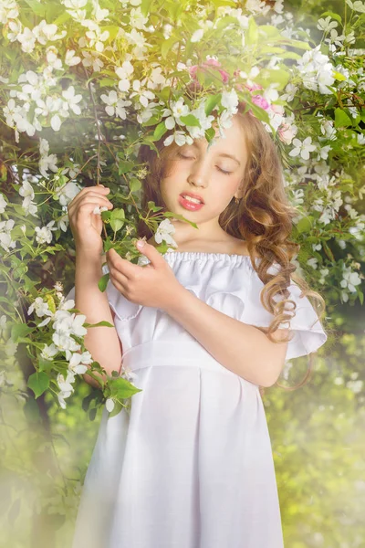 Charmante meisje in een bloeiende boomgaard van Apple op een zonnige lentedag — Stockfoto