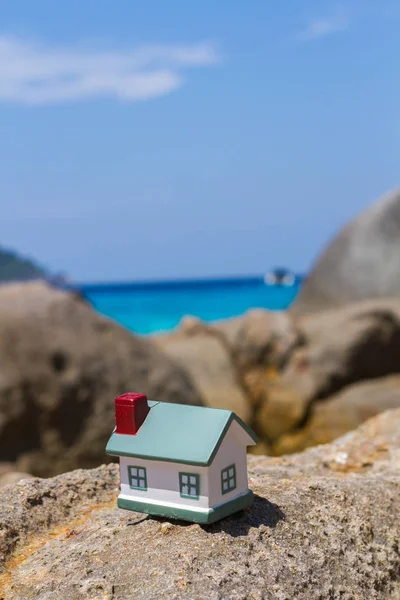 Toy houses standing on rock on background of the sky — Stock Photo, Image