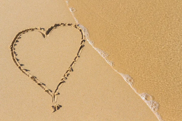 Heart drawn on a sand of beach with the wave of the sea in the morning with place for your text. Summer holiday concept. Romantic love background. Valentine's Day theme. Top view. Copy space. — Stock Photo, Image