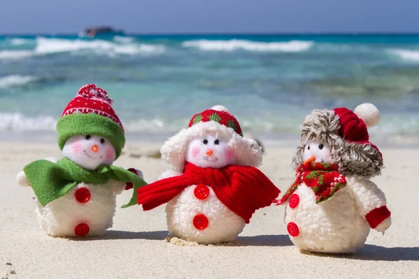 Family of Snowmen in santa hats at tropical beach. New Year's and Christmas holiday in hot countries concept. — Stock Photo, Image