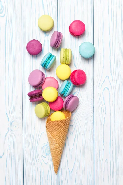 Almond cookies crumbled from waffle cone on light wooden background — Stock Photo, Image