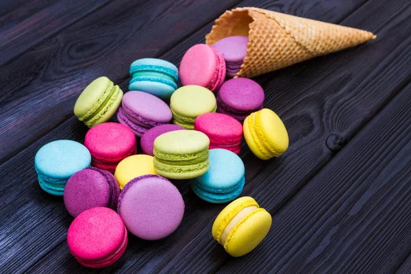 Galletas de almendras desmenuzadas de cono de gofre sobre fondo de madera oscura — Foto de Stock