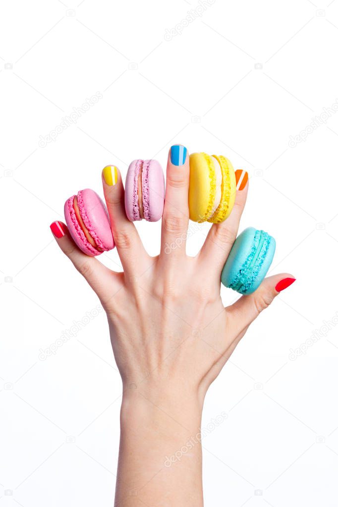 Female hand holding almond cookies on white background.
