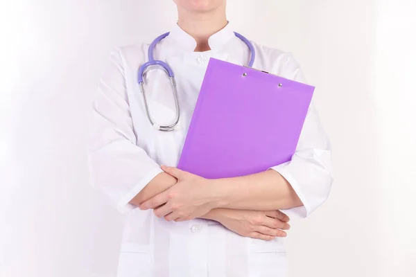 Doctor en bata blanca con estetoscopio, con carpeta en la mano, sobre fondo blanco aislado . —  Fotos de Stock