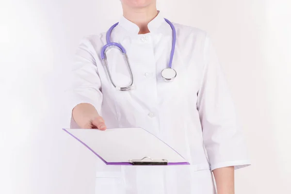 Doctor en bata blanca con estetoscopio, con carpeta en la mano, sobre fondo blanco aislado . —  Fotos de Stock