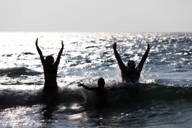 Sudan atlayan insanların silueti. Mutlu insanlar.