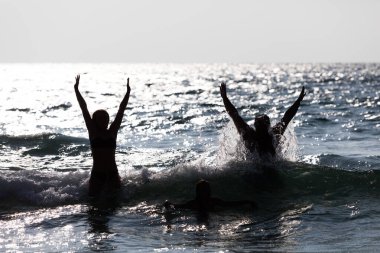 Sudan atlayan insanların silueti. Mutlu insanlar.