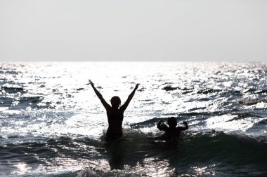 Sudan atlayan insanların silueti. Mutlu insanlar.