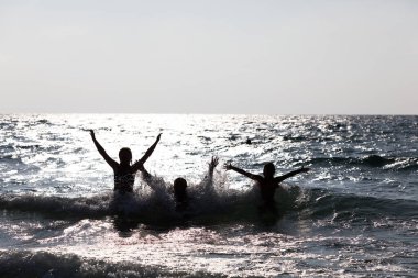 Sudan atlayan insanların silueti. Mutlu insanlar.