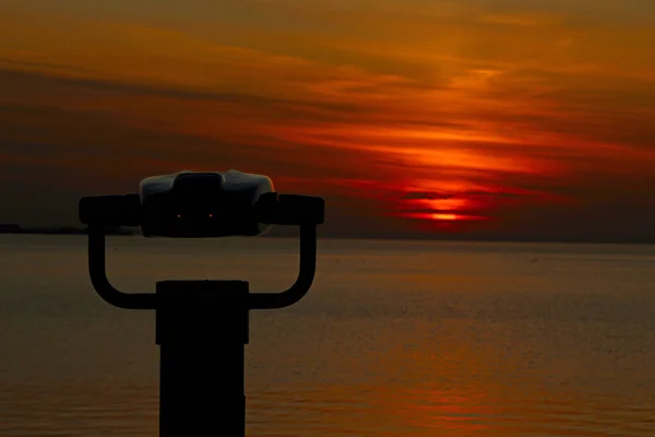 Stationaire Verrekijker Met Ondergaande Zon Weerspiegeld Lenzen Oceaan — Stockfoto