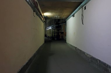 Bir ampulle aydınlatılmış eski bir evin kasvetli geçidi