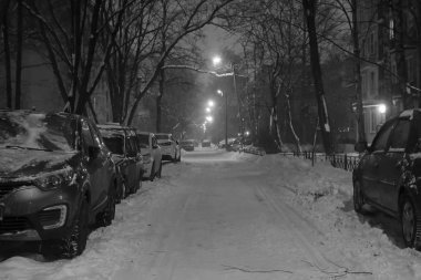 Soğuk bir kış gecesinde, yol boyunca park etmiş arabalar avluda.                 