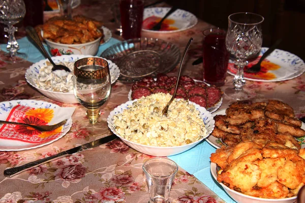 Evde kutlama için salata ve abur cuburla servis edilen tatil masası.