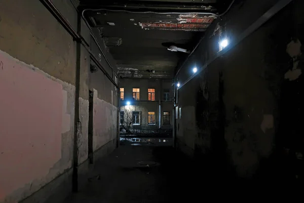 電球が家の窓を照らす暗い門 — ストック写真