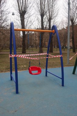 Çocuk parkında salıncak, karantina için uyarı bandıyla sarılmış.