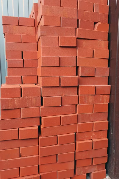 Tuğla duvar inşaatı için turuncu tuğlalar dizilmiş.