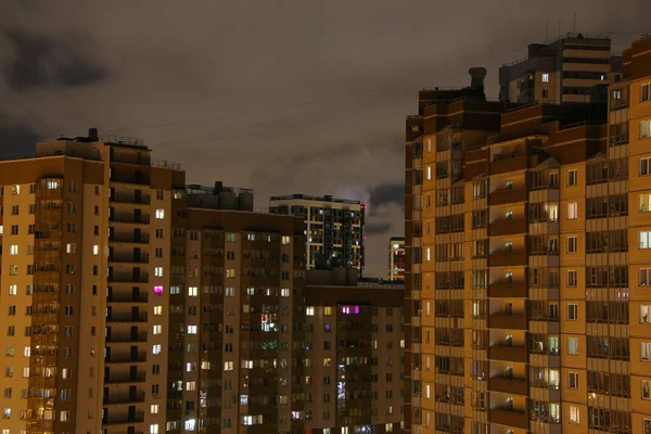 Miejskie Wielopiętrowe Budynki Oświetlonych Oknach Nocy Pod Zachmurzonym Niebem — Zdjęcie stockowe