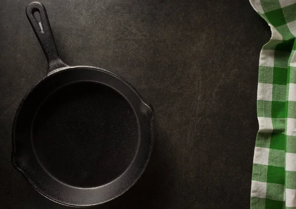 Сковородка и салфетка на черном — стоковое фото
